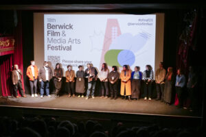 Image of the berwick staff, board, and programme team on stage in the cinema.