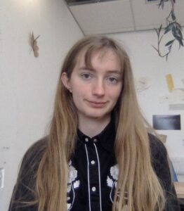 Headshot of Rosalind with long blond hair, wearing a black shirt.