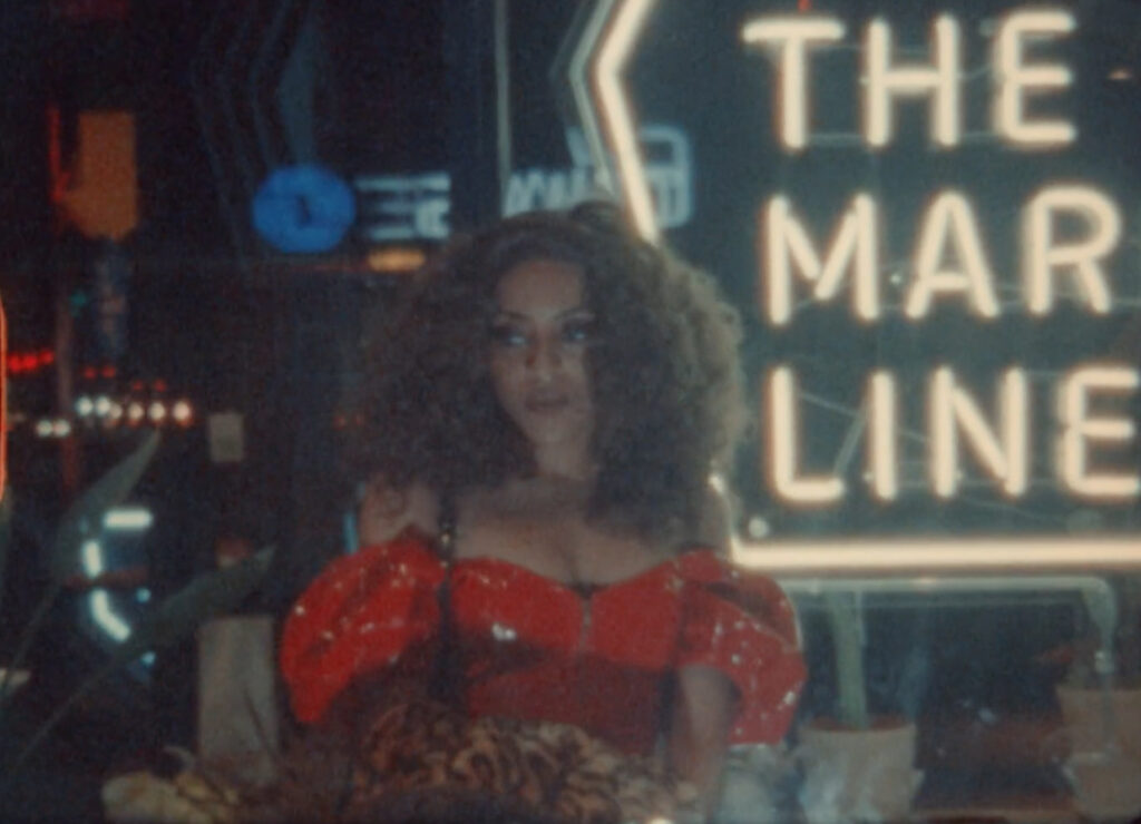 woman looks to the side, dressed in red