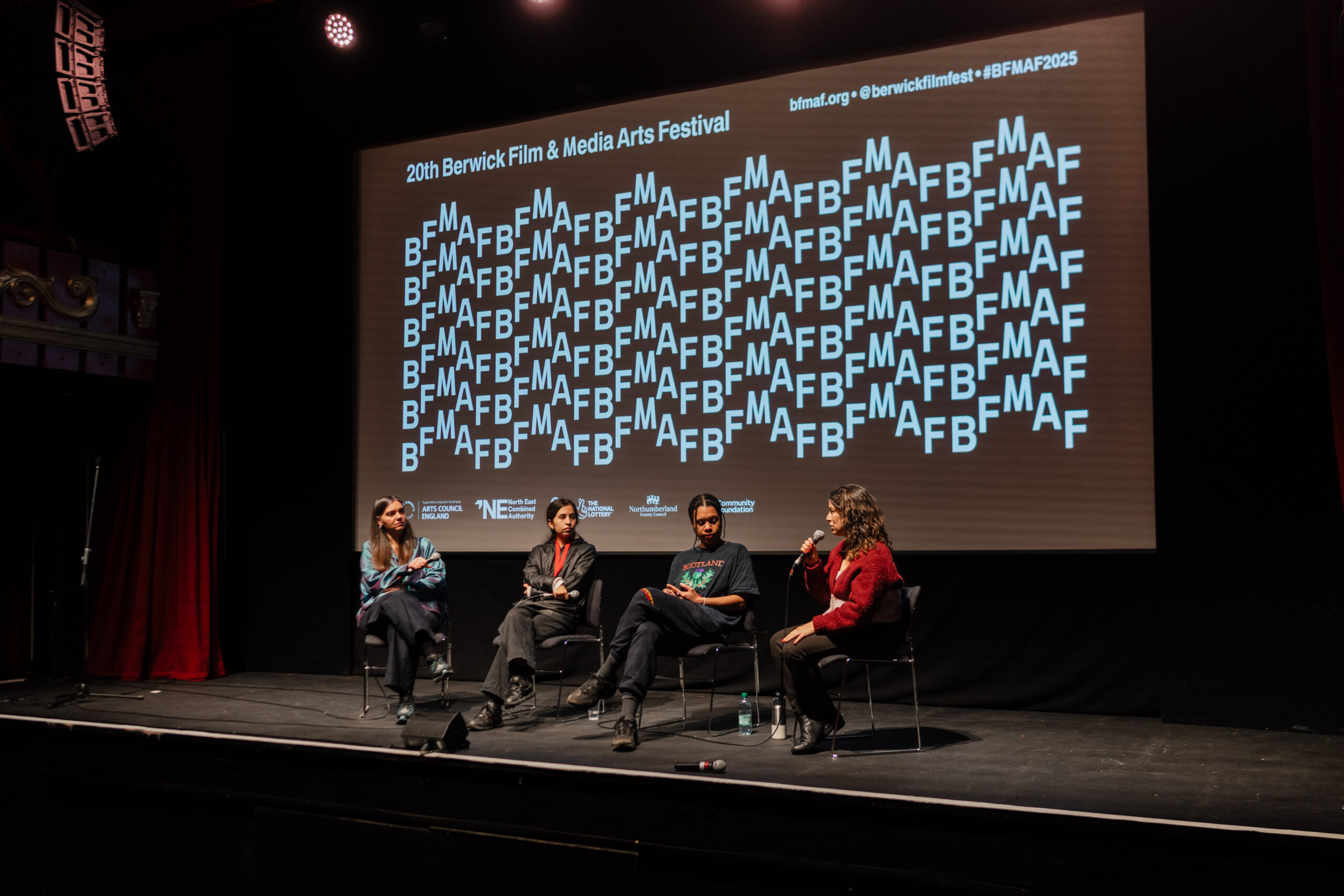 Four people in a Q&A on a stage.