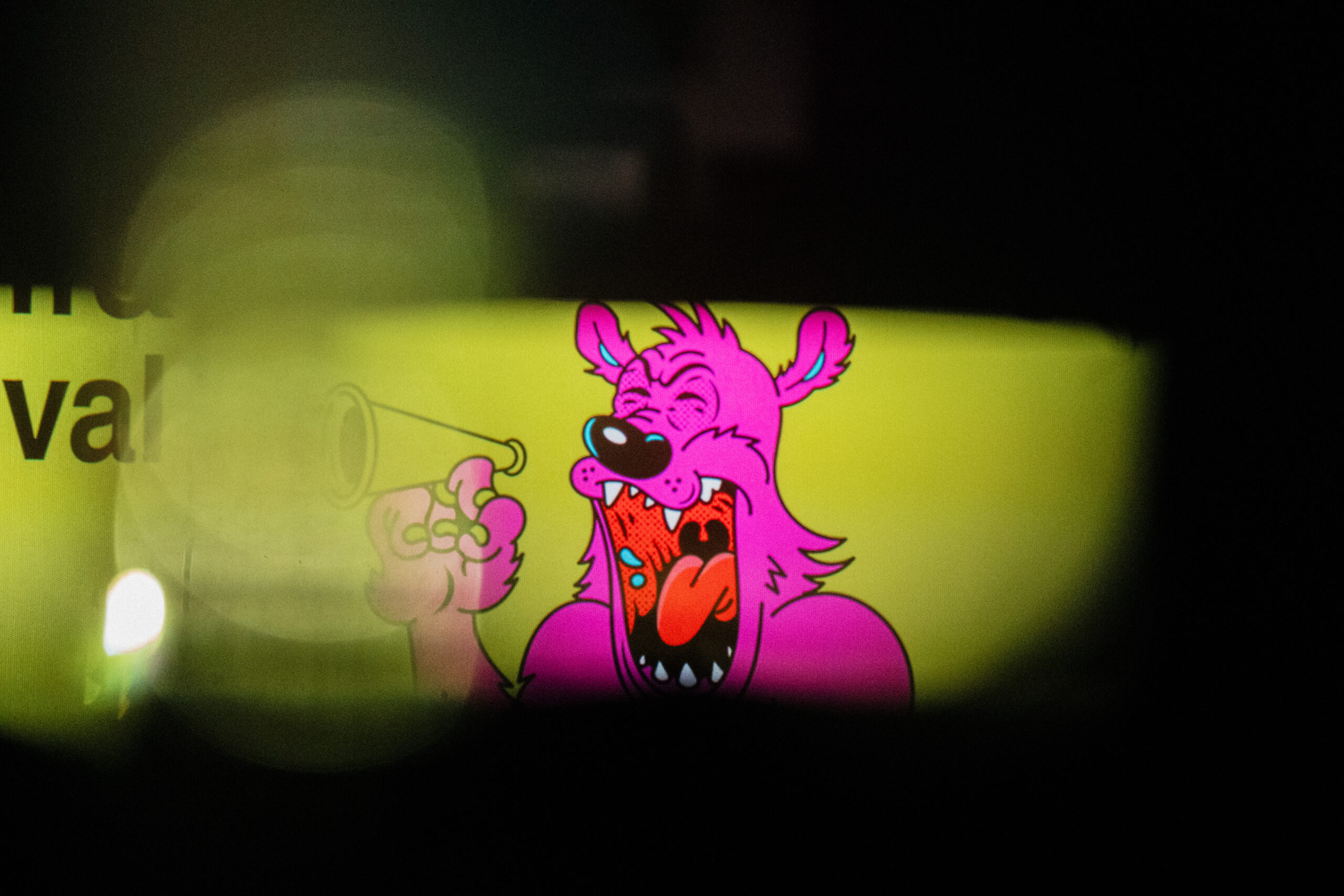 bright pink BFMAF bear against yellow background, seen through a crack